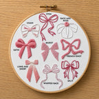 Embroidery hoop with embroidered bows on a wooden surface