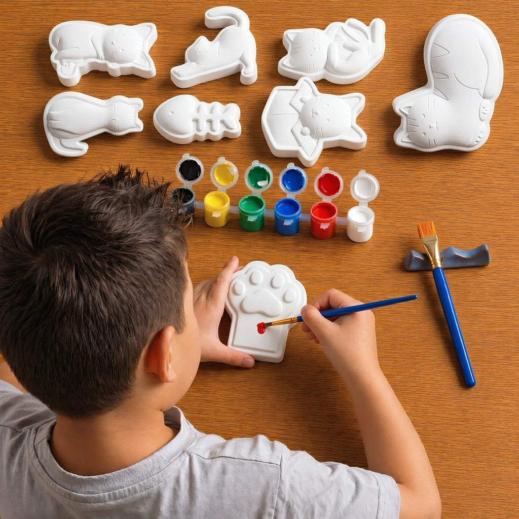 Child painting a white concrete shapes of a paw print with various colors on a wooden table.