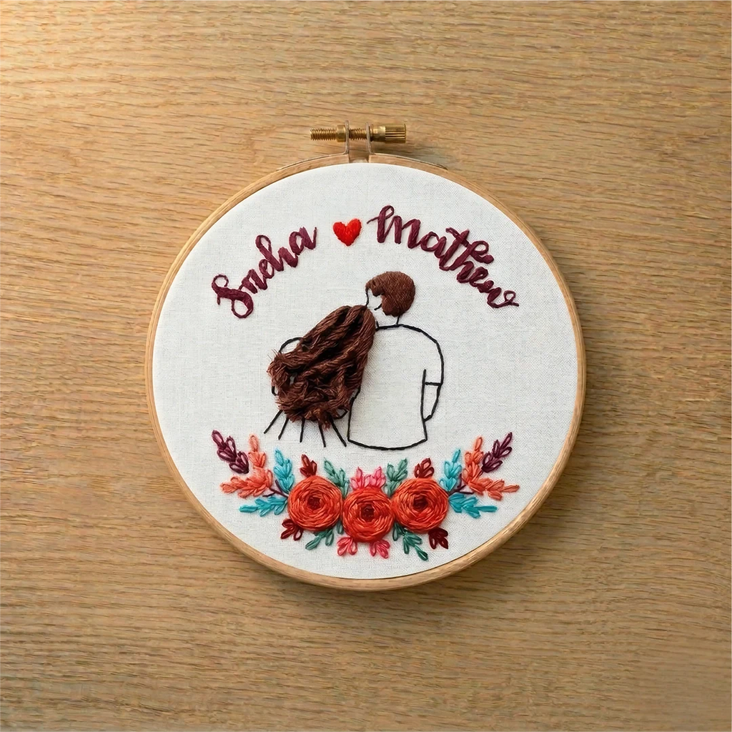 Embroidery hoop with a couple design and floral elements on a wooden surface