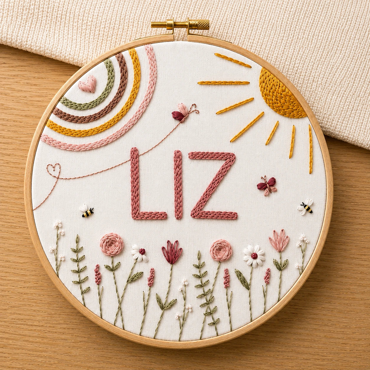 Embroidery hoop with embroidered name 'LIZ' (custom name)and floral designs on a wooden surface