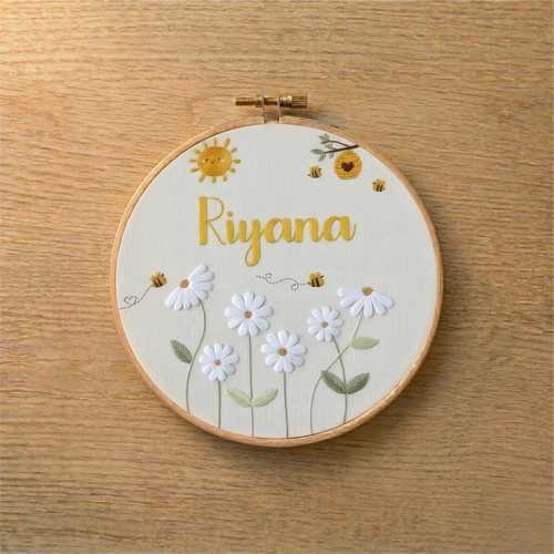 Embroidery hoop with floral design and 'Riyana' text(custom name) on a wooden surface