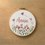 Embroidery hoop with floral design and embroidered name 'Annie'(custom name) on a wooden surface