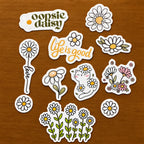 Daisy-themed stitch and stitch stickers on a textured surface