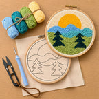Embroidery hoop with a landscape design, yarn balls, and  punch needle embroidery tools on a wooden surface