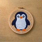 Punch needled penguin in a wooden hoop on a wooden surface