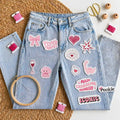 Pookie cute-themed  stitch and stitch stickers on blue jean on textured surface with embroidery tools like hoop, needle, threads and scissors 