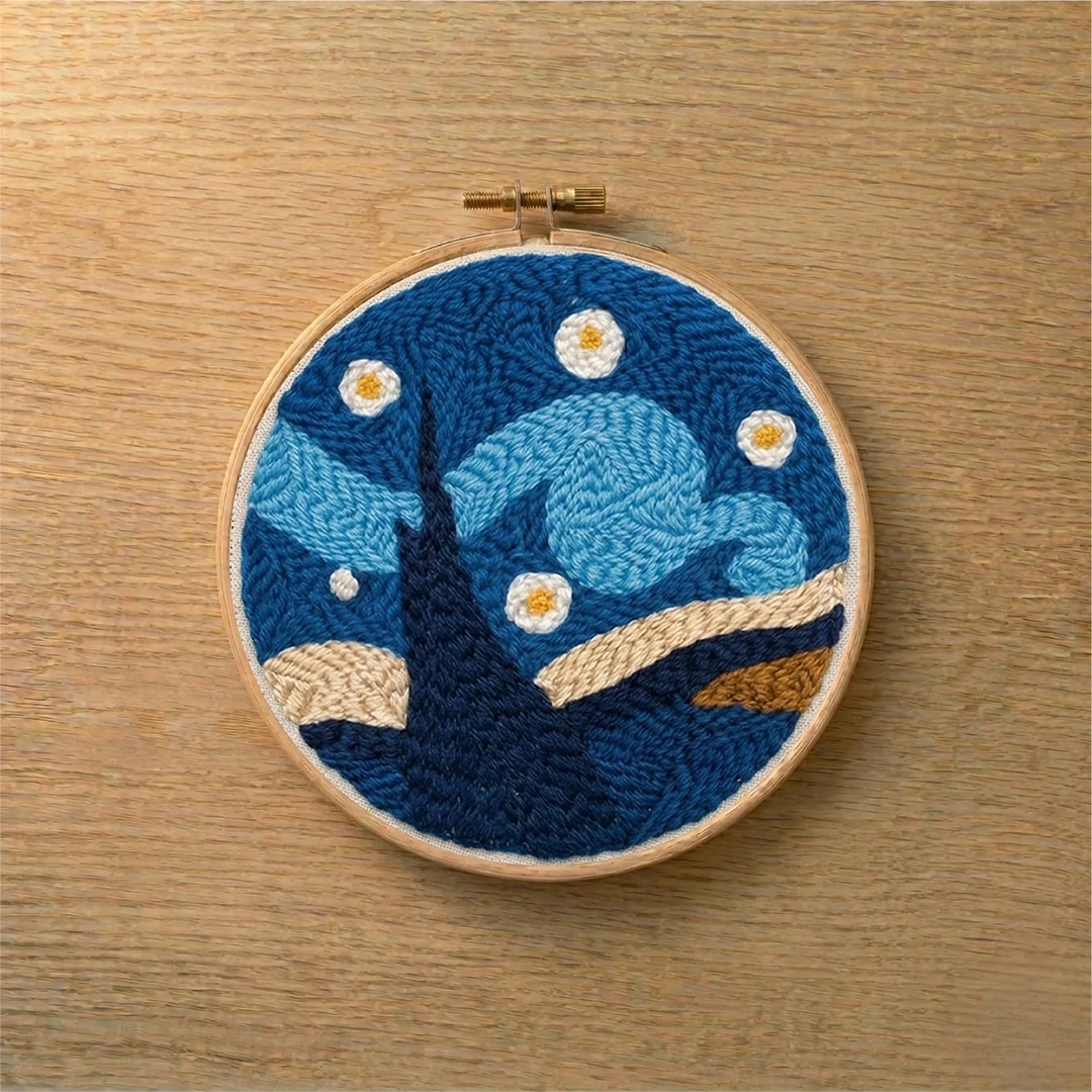 Embroidery hoop with a punch needled starry night design on a wooden surface