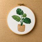 Embroidery hoop with a plant design on a wooden surface