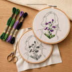 Embroidery hoops with floral designs ,woman face and embroidery threads on a wooden surface
